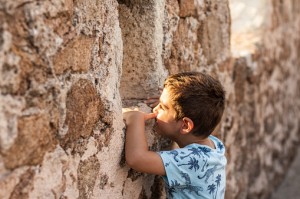 Little boy looking through the wall